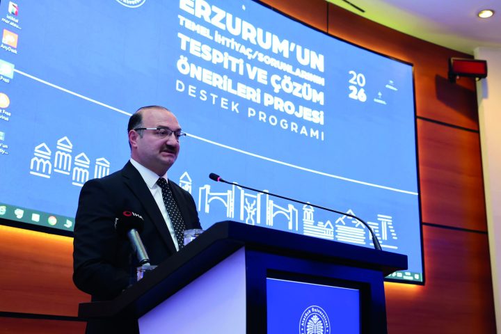 Program afişinin önündeki kürsüde açılış konuşması yapılıyor