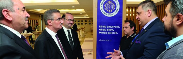 Program afişinin önünde plaket alan katılımcılar